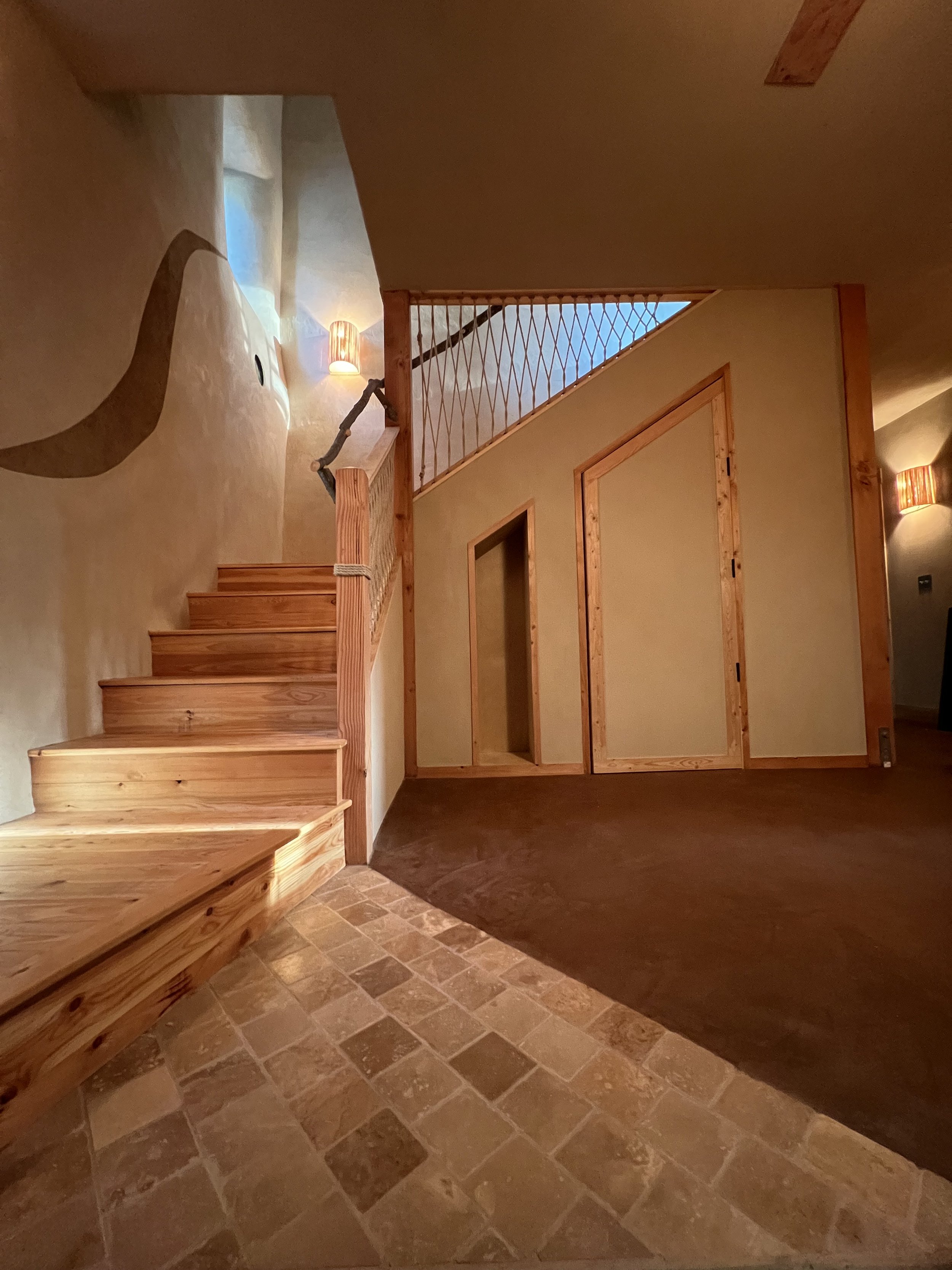 Modern natural building exterior with earthen plaster and timber beams